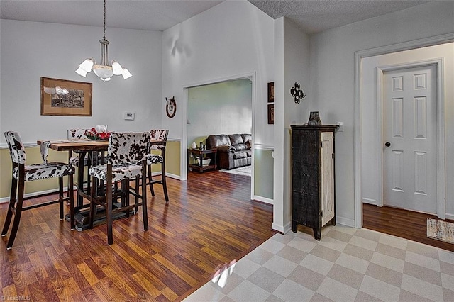 dining space featuring hardwood / wood-style floors, high vaulted ceiling, a chandelier, and a textured ceiling