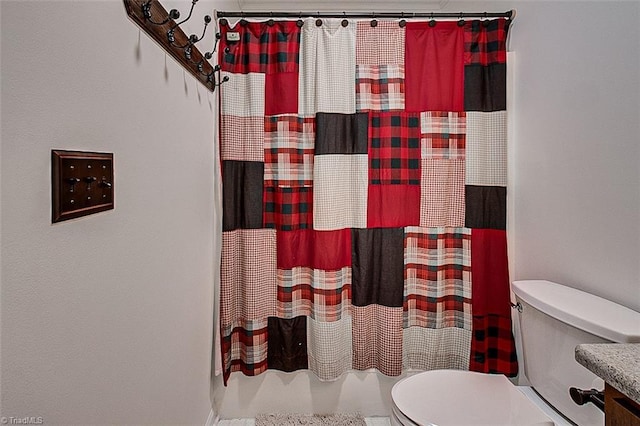 bathroom featuring curtained shower, vanity, and toilet