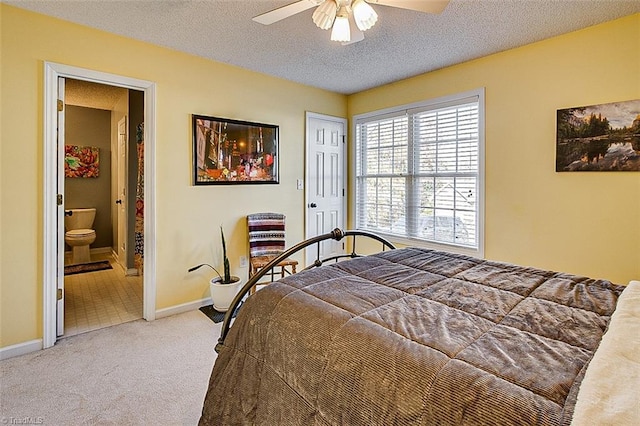 carpeted bedroom with ceiling fan, ensuite bath, a textured ceiling, and a closet