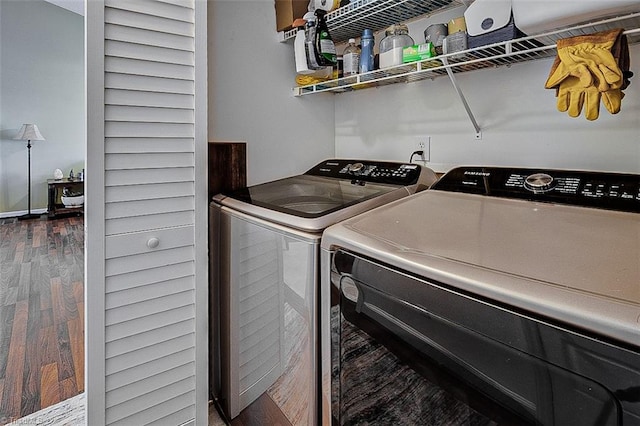 laundry area with washer and clothes dryer and dark wood-type flooring