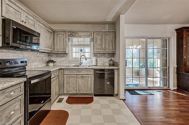 kitchen with sink, stainless steel appliances, tasteful backsplash, a textured ceiling, and light wood-type flooring