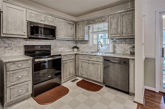 kitchen featuring backsplash, light hardwood / wood-style floors, sink, and stainless steel appliances