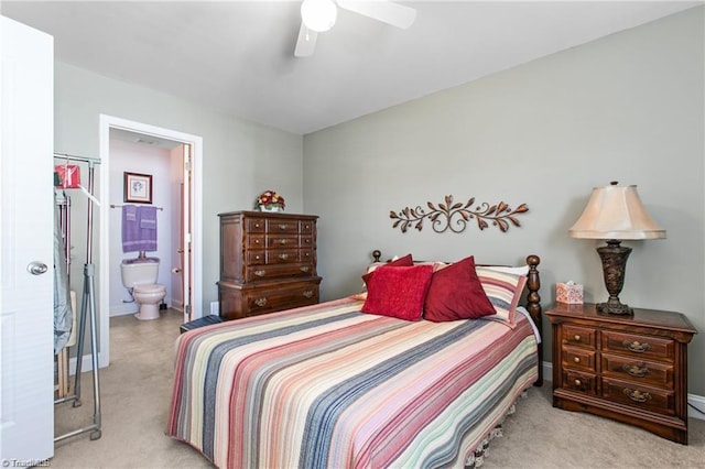 carpeted bedroom with ensuite bathroom and ceiling fan