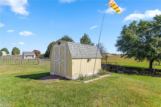 view of outbuilding featuring a rural view and a lawn