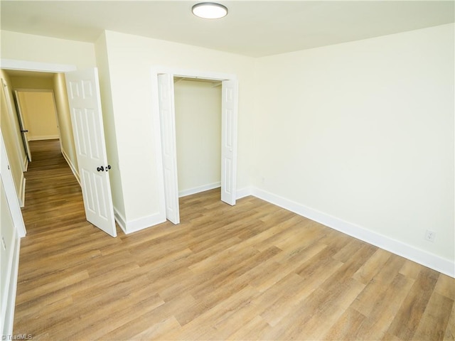 unfurnished bedroom with light hardwood / wood-style floors and a closet