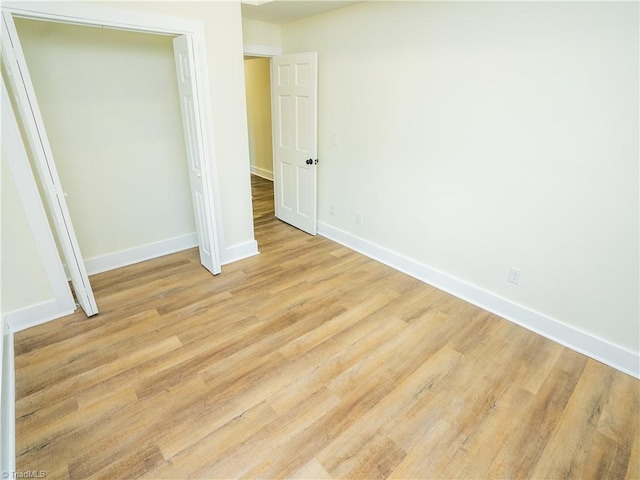 unfurnished bedroom with light hardwood / wood-style floors and a closet