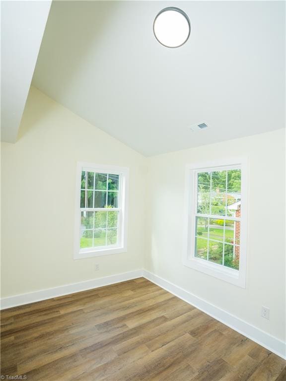 empty room with lofted ceiling and wood-type flooring