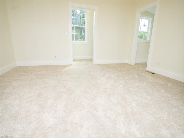 unfurnished room featuring light carpet