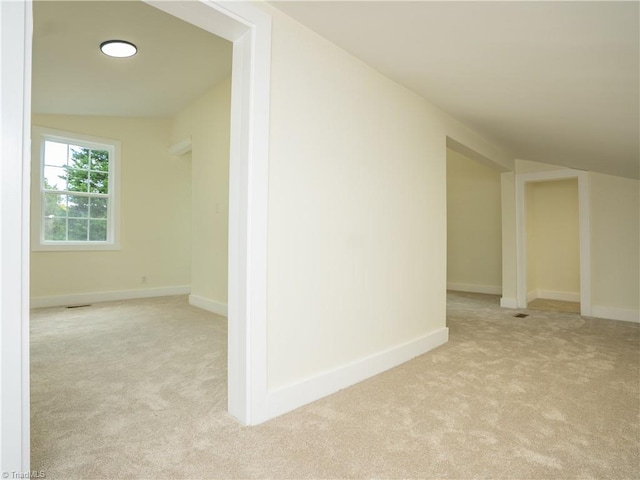 interior space with light colored carpet and vaulted ceiling