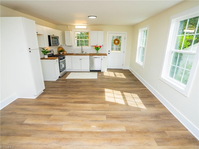 kitchen with stainless steel appliances, light hardwood / wood-style floors, and sink