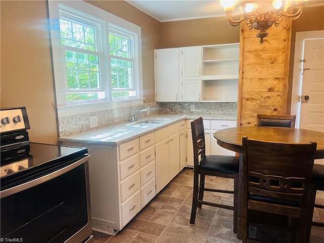 322 E Independence Blvd, Mount Airy, NC 27030 - kitchen with stainless steel electric stove, open shelves, light countertops, white cabinets, and a chandelier