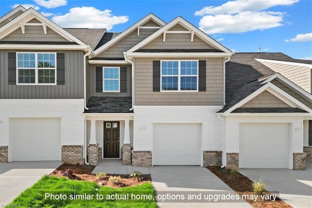 view of front of home with concrete driveway, a garage, board and batten siding, and stone siding