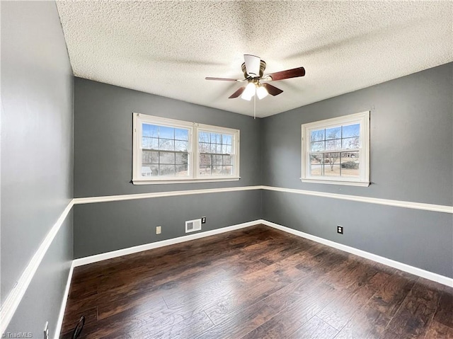 unfurnished room with ceiling fan, a textured ceiling, and dark hardwood / wood-style flooring