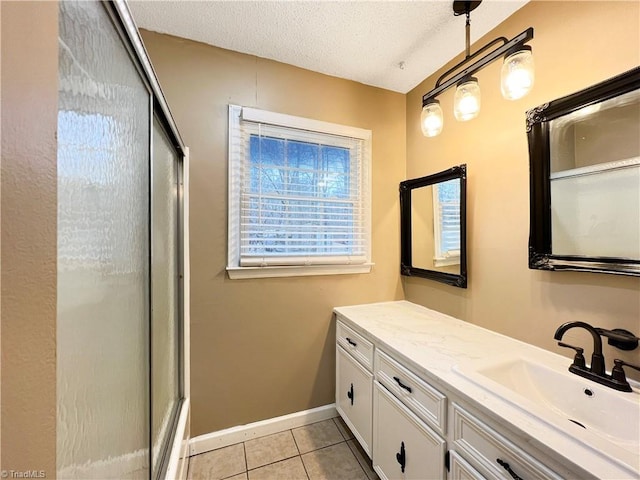 bathroom with a textured ceiling, tile patterned floors, and vanity