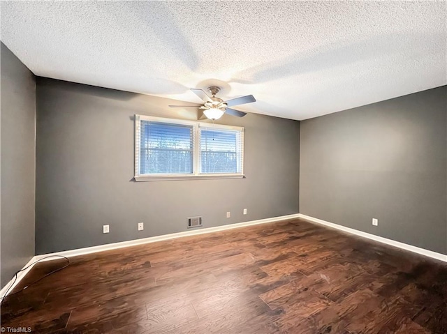 spare room with ceiling fan, dark wood-type flooring, and a textured ceiling