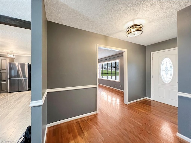 entrance foyer with light hardwood / wood-style floors and a textured ceiling