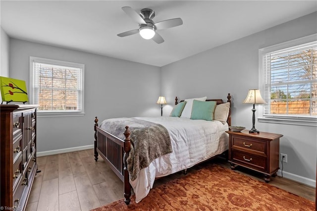 bedroom featuring multiple windows, baseboards, and wood finished floors