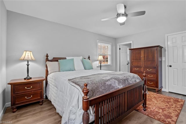 bedroom with light wood-style floors, ceiling fan, and baseboards