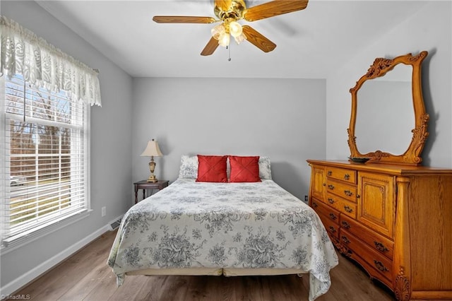 bedroom featuring a ceiling fan, baseboards, and wood finished floors