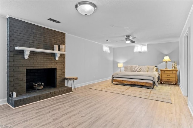 bedroom featuring a fireplace, wood finished floors, visible vents, and baseboards