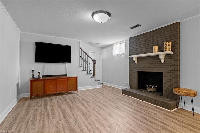 living area featuring a brick fireplace, visible vents, crown molding, a textured ceiling, and light wood-style floors