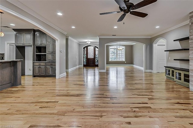 unfurnished living room featuring crown molding, light hardwood / wood-style floors, and ceiling fan