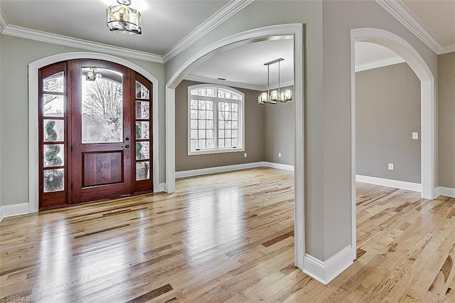 foyer entrance featuring crown molding, a notable chandelier, and light wood-type flooring