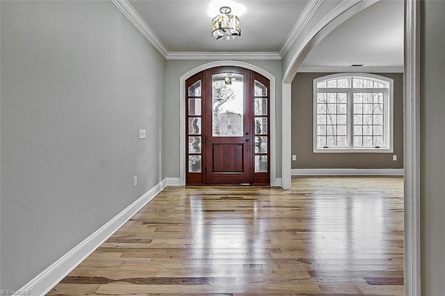 foyer featuring ornamental molding, plenty of natural light, and light hardwood / wood-style flooring