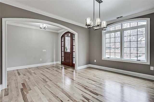 entrance foyer featuring an inviting chandelier, crown molding, and light wood-type flooring