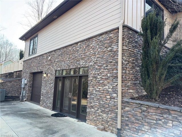 view of property exterior with a garage and central AC