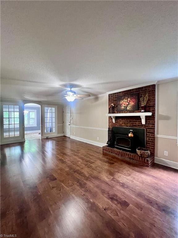 5608 Fred Lineberry Rd, Randleman, NC 27317 - unfurnished living room featuring baseboards, a textured ceiling, a ceiling fan, wood finished floors, and arched walkways