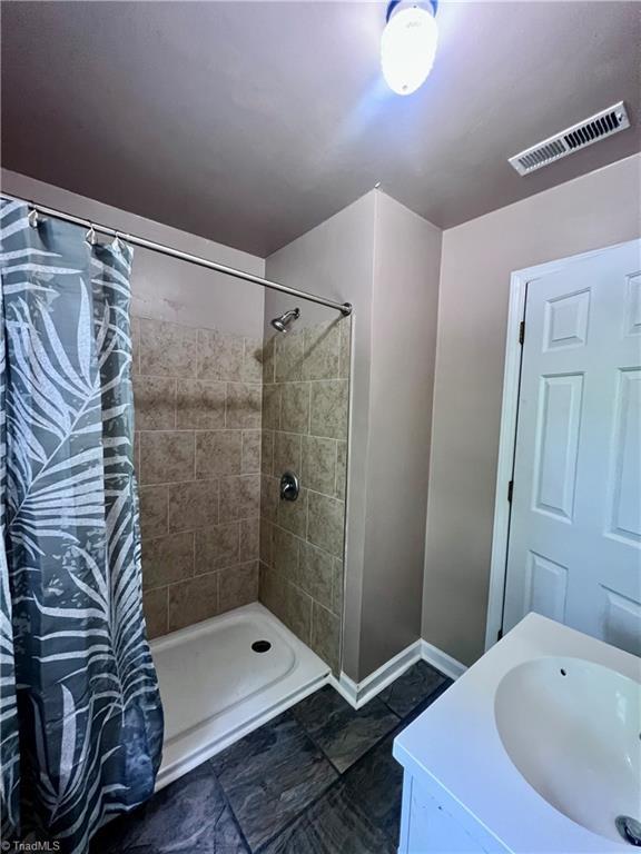 5608 Fred Lineberry Rd, Randleman, NC 27317 - full bath with tiled shower, baseboards, and vanity
