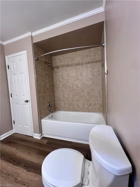 5608 Fred Lineberry Rd, Randleman, NC 27317 - full bathroom with toilet, wood finished floors, shower / bath combination, crown molding, and baseboards