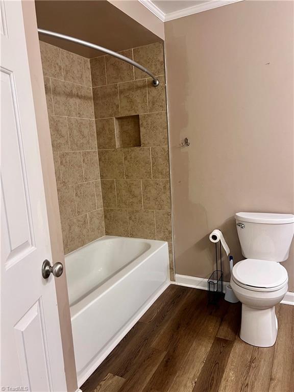 5608 Fred Lineberry Rd, Randleman, NC 27317 - full bath with crown molding, wood finished floors, toilet, shower / washtub combination, and baseboards
