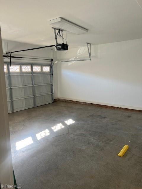 garage featuring a garage door opener and baseboards