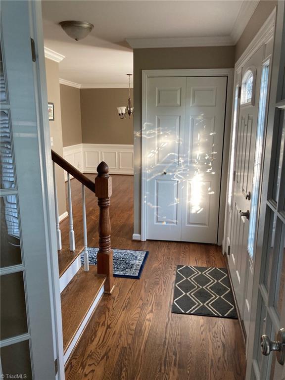 3908 Sandlewood Rd, High Point, NC 27265 - foyer with wood finished floors, ornamental molding, and stairway