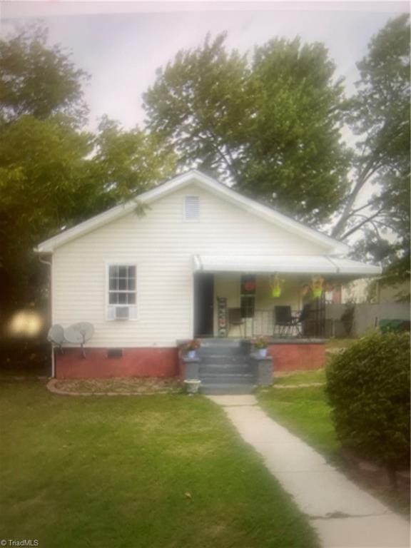 back of house with crawl space, a porch, and a lawn