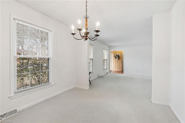 interior space with plenty of natural light, light carpet, and an inviting chandelier