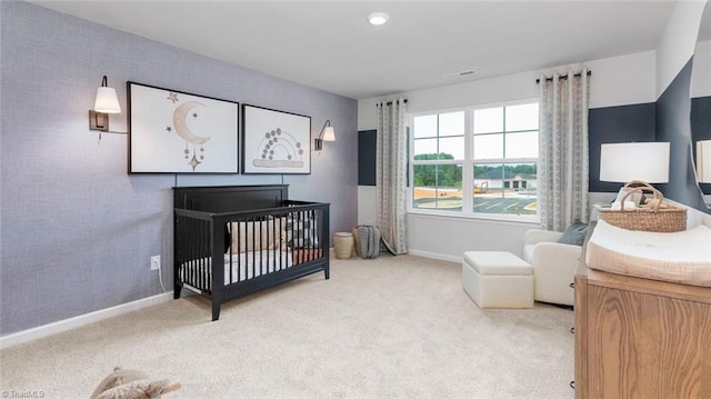 bedroom with light colored carpet and a crib