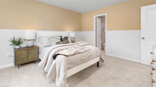 bedroom with light colored carpet and ensuite bathroom