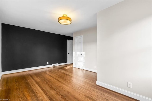 unfurnished room with hardwood / wood-style flooring