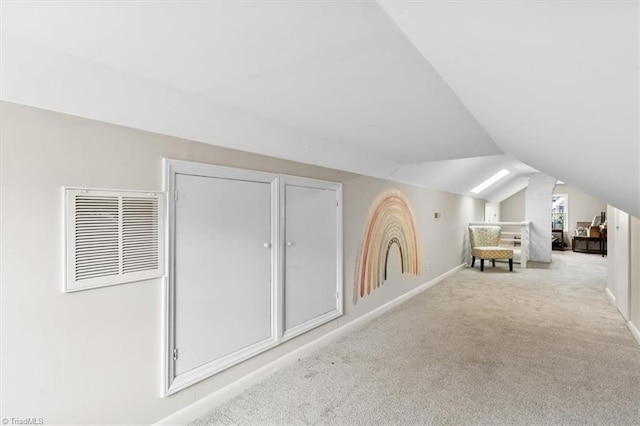 additional living space featuring light carpet and vaulted ceiling