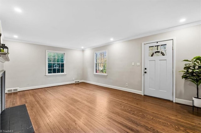 foyer entrance featuring hardwood / wood-style flooring, crown molding, and a wealth of natural light