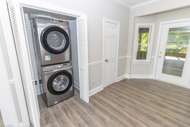 laundry room with laundry area, stacked washer and dryer, ornamental molding, wood finished floors, and baseboards