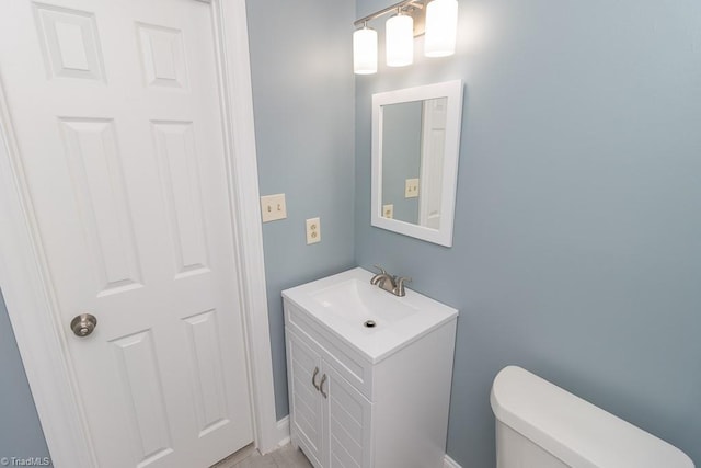 half bath featuring vanity and toilet