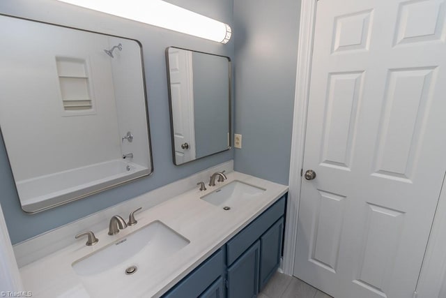 full bathroom with double vanity and a sink
