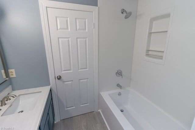 full bath featuring vanity, washtub / shower combination, and wood finished floors