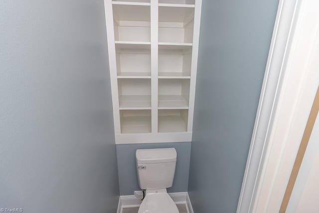 bathroom with baseboards and toilet