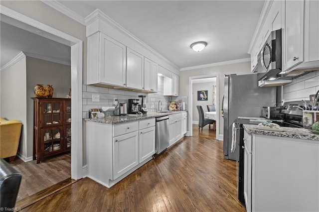 kitchen with dark wood-style floors, appliances with stainless steel finishes, white cabinets, and crown molding