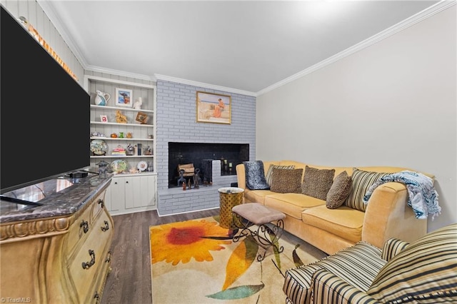 living room featuring crown molding, a fireplace, built in features, and dark wood-style flooring